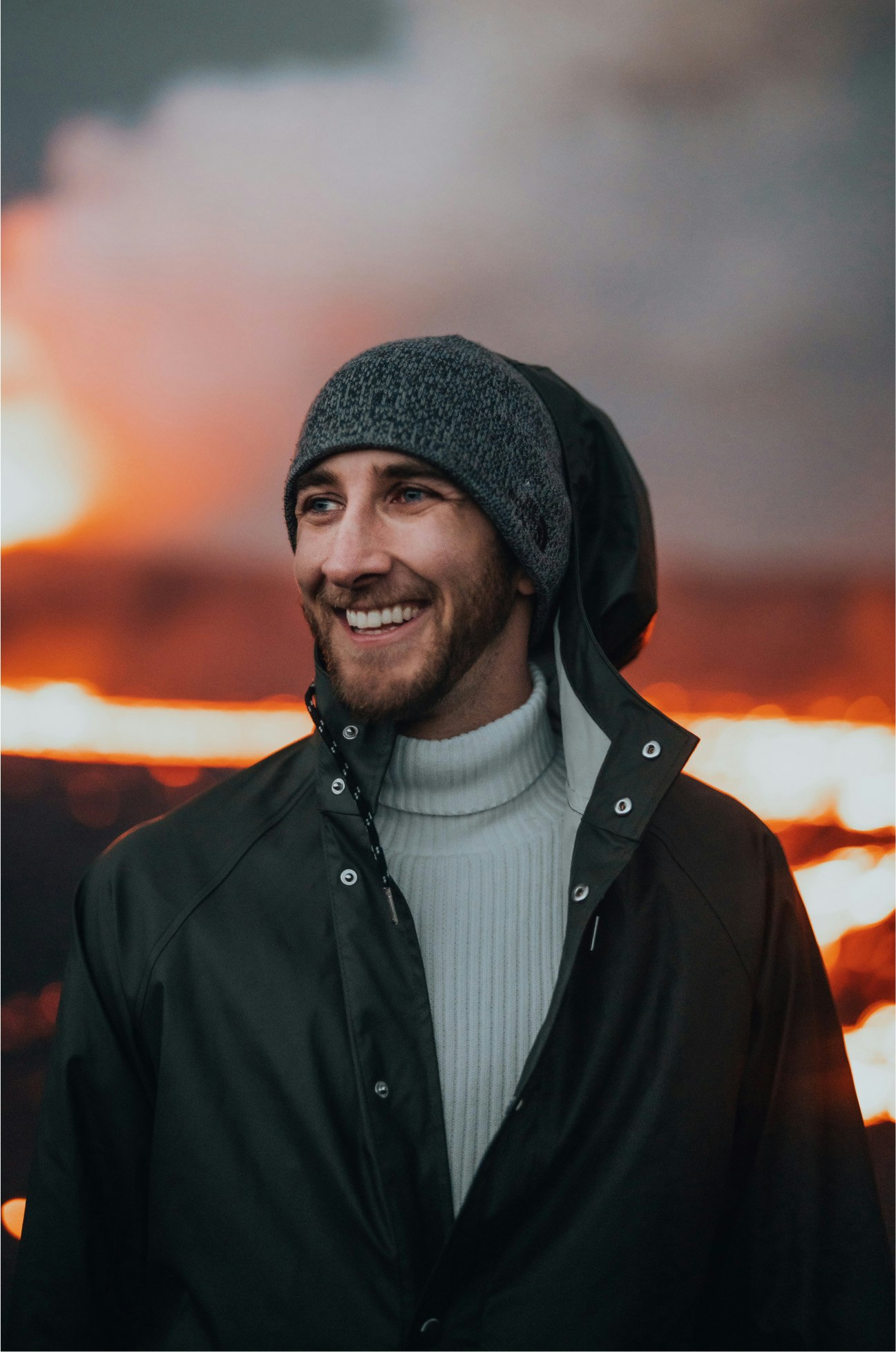 A content creator with long hair focuses on his camera, capturing the scenic beauty of an outdoor landscape, perfect for stock footage